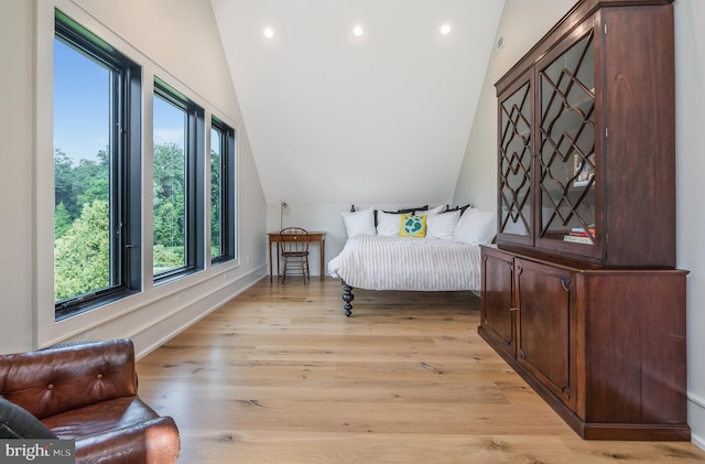 bedroom with light hardwood / wood-style flooring and lofted ceiling