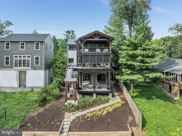 view of front of property featuring a balcony and a front yard