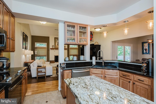 kitchen with stainless steel appliances, light hardwood / wood-style flooring, decorative light fixtures, and sink