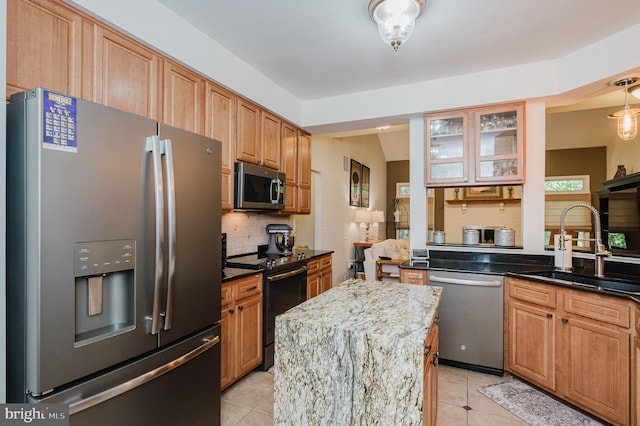 kitchen with stainless steel appliances, light tile patterned floors, dark stone counters, and decorative backsplash