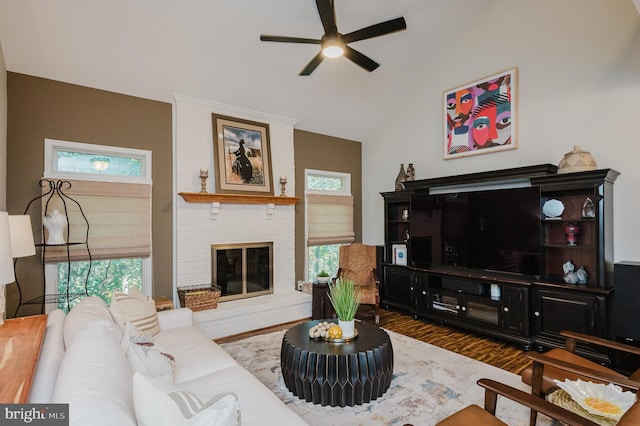 living room featuring dark wood-type flooring, plenty of natural light, vaulted ceiling, and a fireplace