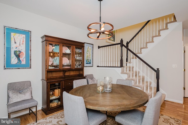 dining area featuring light hardwood / wood-style floors and a notable chandelier