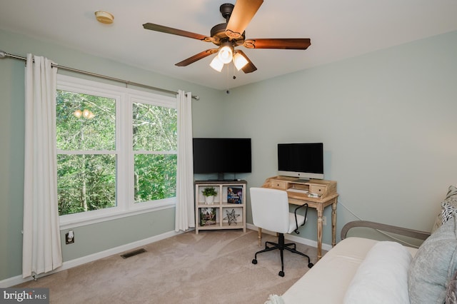 carpeted home office featuring ceiling fan