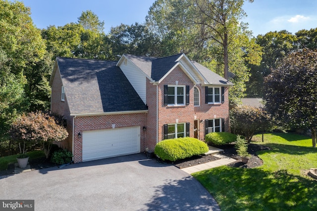 colonial home with a front yard and a garage