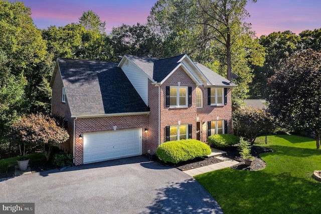 colonial-style house with a garage and a lawn