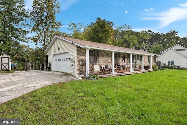 ranch-style home featuring a garage, a storage shed, a front lawn, and covered porch