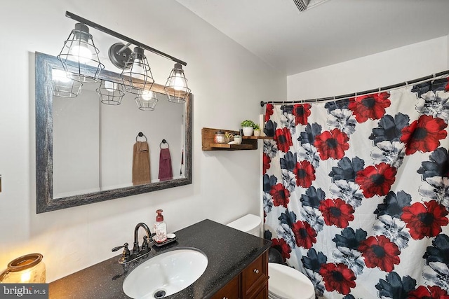 bathroom featuring a shower with shower curtain, vanity, and toilet