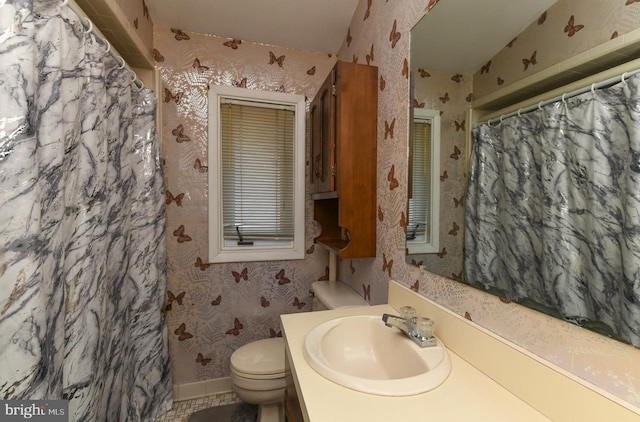 bathroom featuring vanity, toilet, and walk in shower