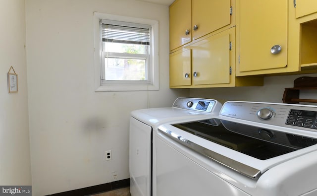 clothes washing area with cabinets and washer and dryer