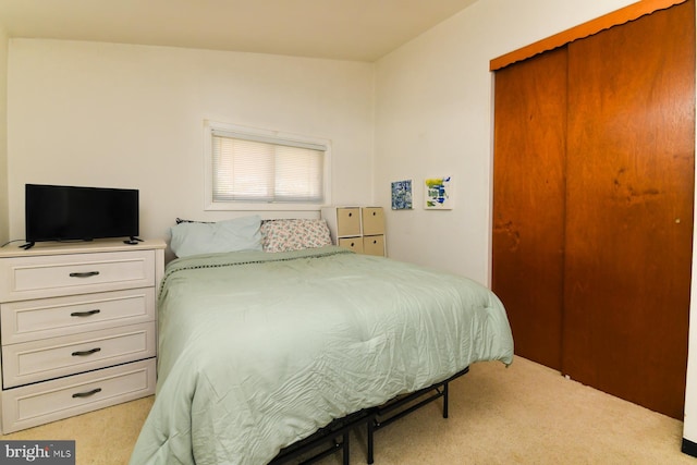 bedroom featuring light colored carpet and a closet