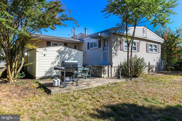 back of property with a patio area and a lawn