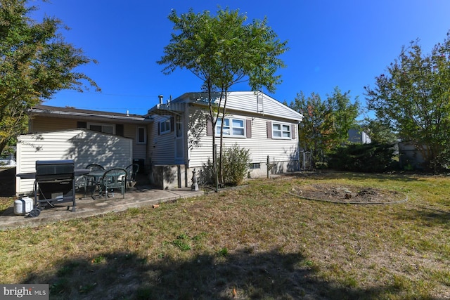 back of house featuring a patio and a lawn