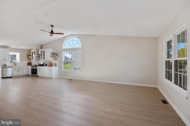 unfurnished living room featuring baseboards, vaulted ceiling, light wood-style flooring, visible vents, and ceiling fan