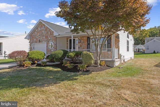 view of front of home featuring covered porch, a garage, stone siding, and a front yard