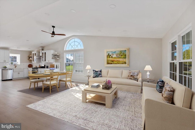 living room featuring recessed lighting, light wood-style flooring, a ceiling fan, and vaulted ceiling