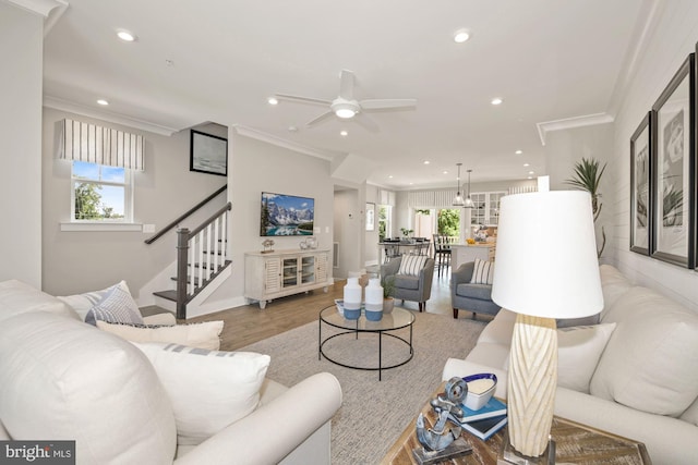 living room featuring hardwood / wood-style floors, ornamental molding, and a healthy amount of sunlight