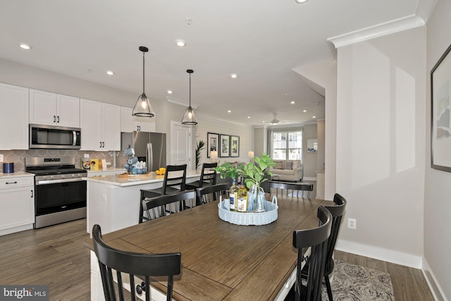 dining space featuring ceiling fan, dark hardwood / wood-style floors, and crown molding