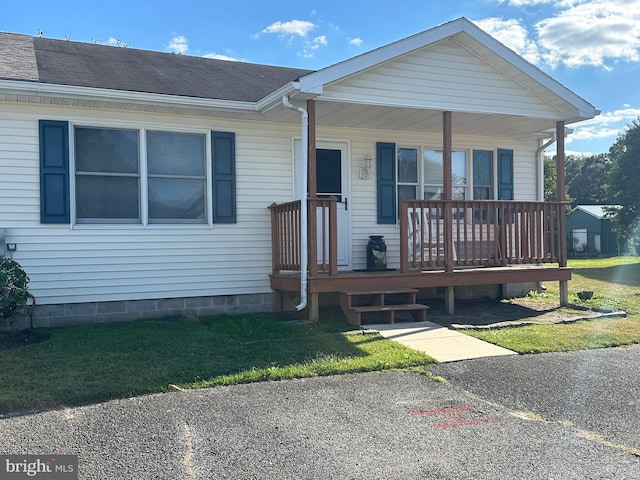 view of front of property with covered porch and a front yard