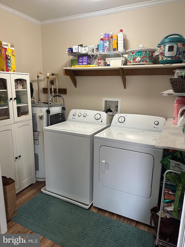 laundry room featuring crown molding, washer and clothes dryer, water heater, cabinets, and dark wood-type flooring