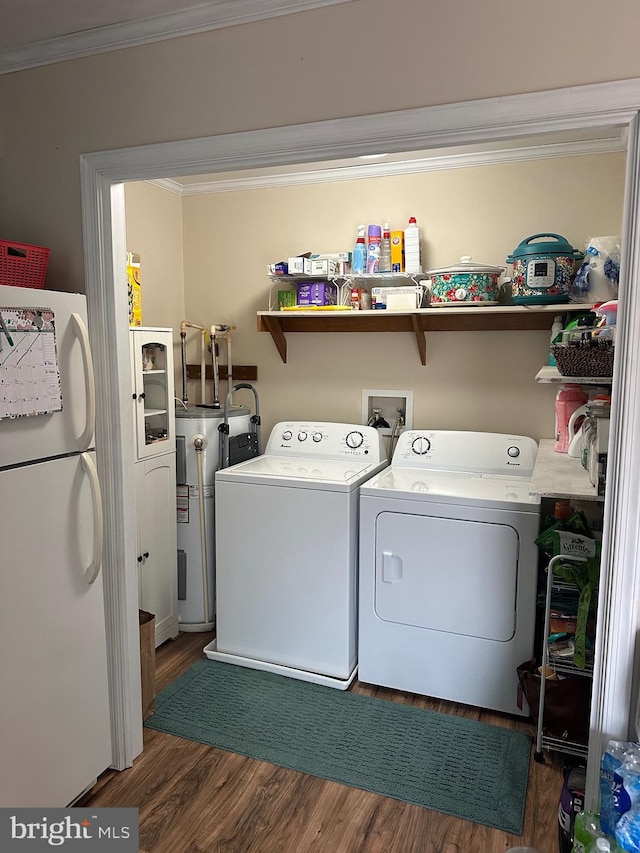 washroom featuring washing machine and dryer, water heater, crown molding, and dark hardwood / wood-style flooring