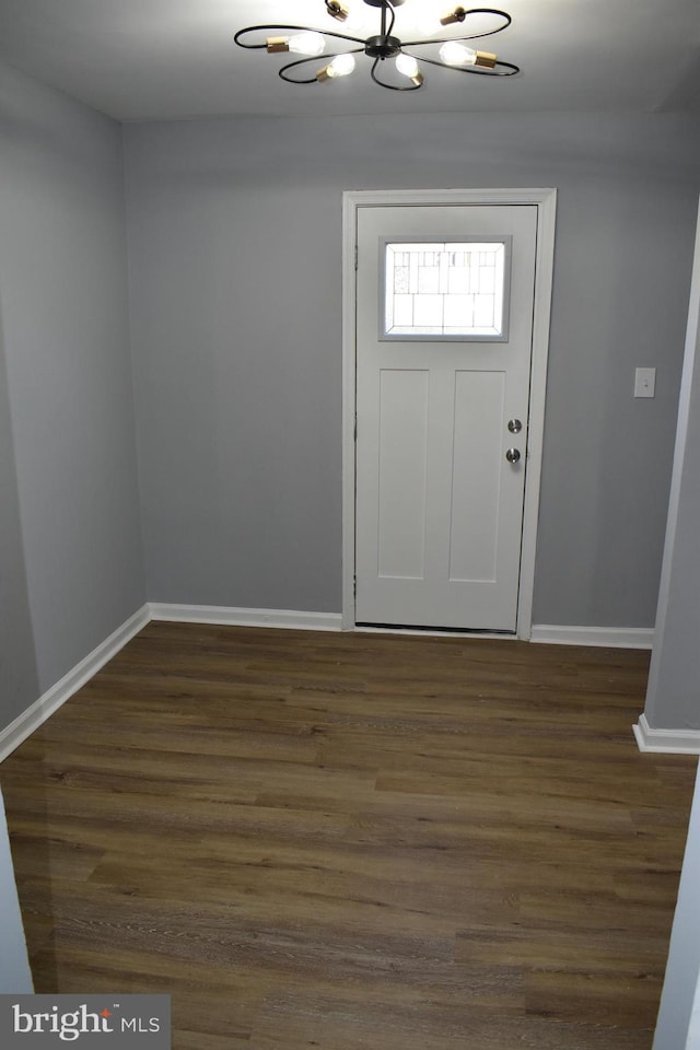 foyer entrance with a notable chandelier and dark hardwood / wood-style flooring