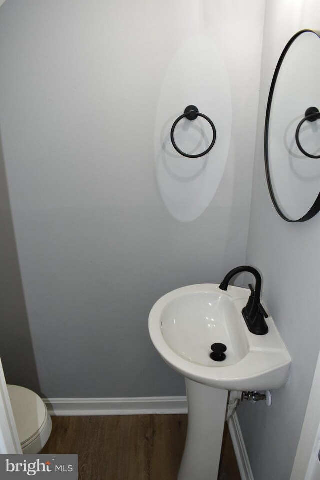 bathroom featuring hardwood / wood-style floors and toilet