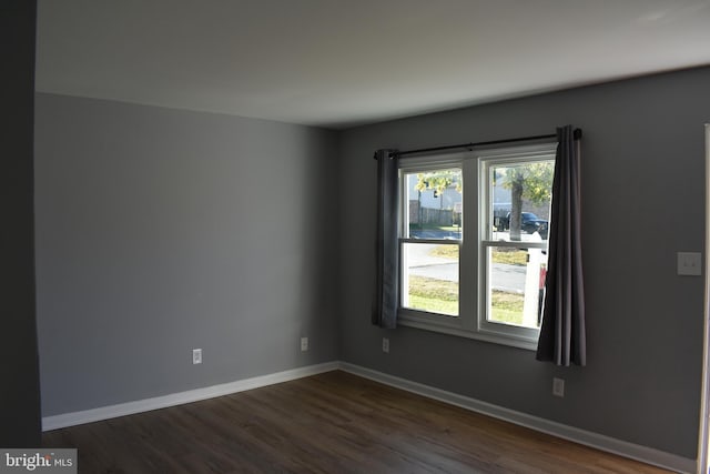 unfurnished room with dark hardwood / wood-style flooring