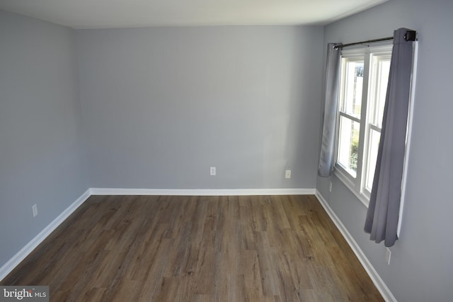 unfurnished room featuring dark wood-type flooring