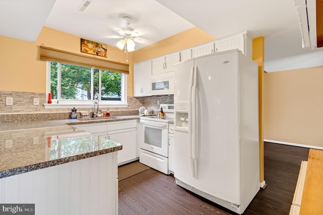 kitchen featuring sink, white appliances, dark wood-type flooring, white cabinetry, and decorative backsplash