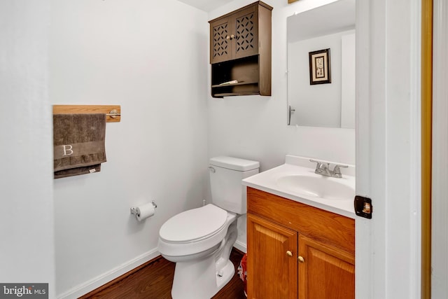 bathroom featuring wood-type flooring, vanity, and toilet