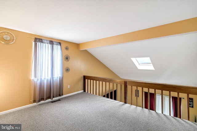 additional living space featuring carpet and vaulted ceiling with skylight