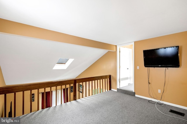 additional living space with carpet floors and vaulted ceiling with skylight