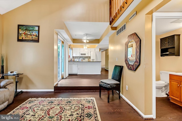 interior space with ceiling fan, lofted ceiling, and dark wood-type flooring