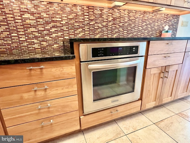 kitchen with stainless steel oven and light tile patterned flooring