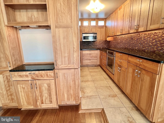 kitchen featuring light tile patterned floors, backsplash, and stainless steel appliances