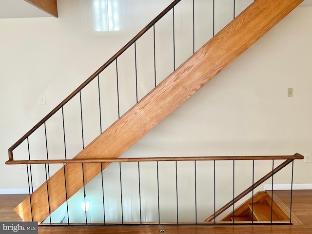 staircase featuring beamed ceiling and wood-type flooring