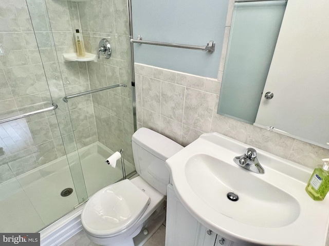 bathroom featuring walk in shower, sink, tile walls, and toilet