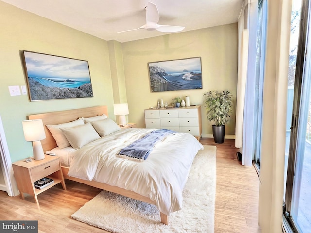 bedroom featuring multiple windows, light hardwood / wood-style flooring, and ceiling fan