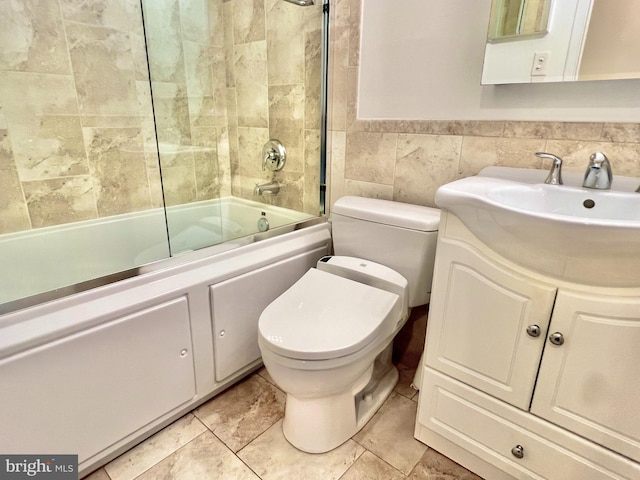 full bathroom featuring vanity, toilet, enclosed tub / shower combo, and tile walls