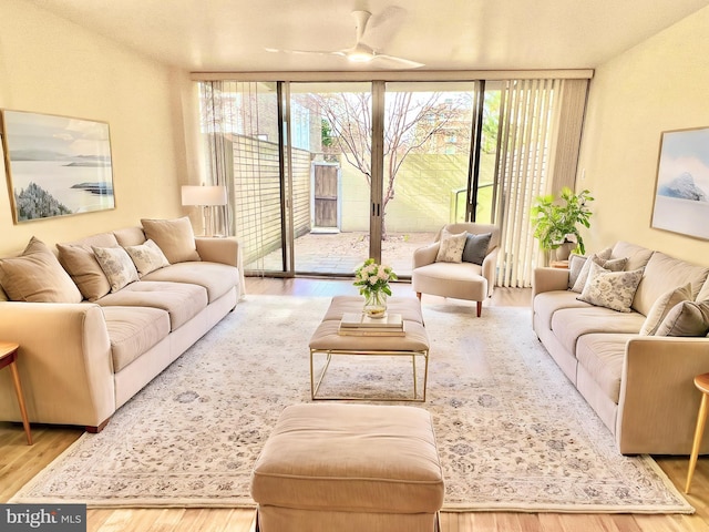 living room featuring floor to ceiling windows, ceiling fan, and hardwood / wood-style floors