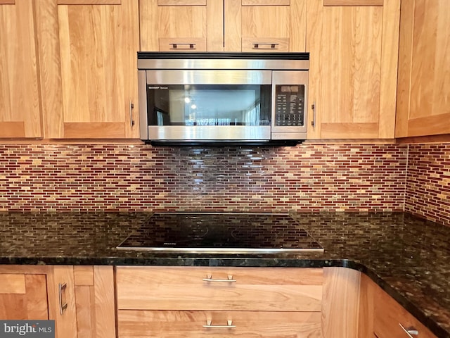 kitchen featuring decorative backsplash, light brown cabinets, black electric cooktop, and dark stone counters