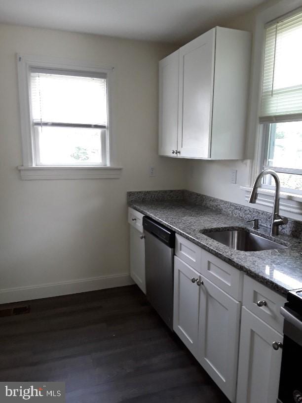 kitchen featuring stainless steel appliances, white cabinetry, a healthy amount of sunlight, and dark hardwood / wood-style flooring