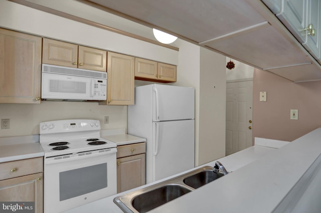 kitchen featuring light brown cabinetry, sink, and white appliances