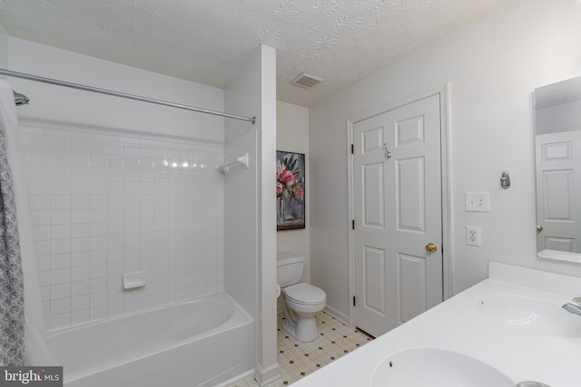 full bathroom featuring tiled shower / bath combo, vanity, a textured ceiling, and toilet