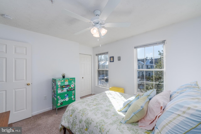 carpeted bedroom with ceiling fan and a closet