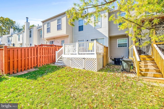 rear view of property with cooling unit, a deck, and a lawn