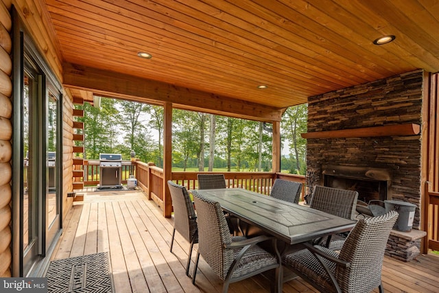 wooden deck with an outdoor stone fireplace