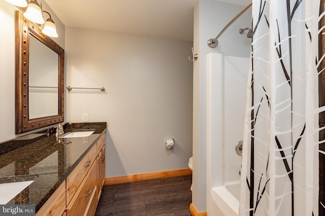 full bathroom with hardwood / wood-style floors, vanity, shower / bath combo, and toilet