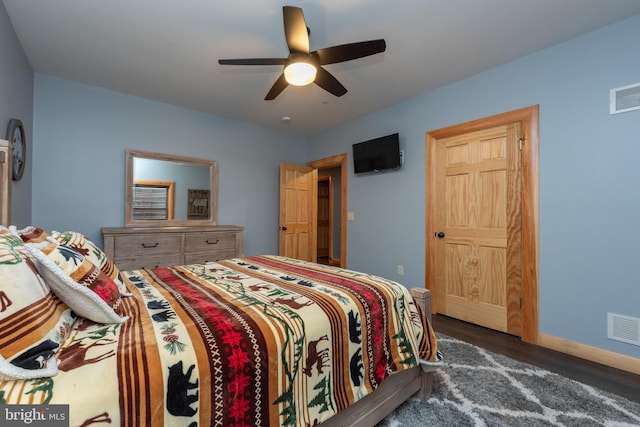 bedroom with dark hardwood / wood-style flooring and ceiling fan