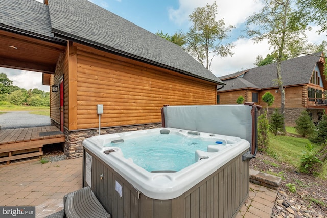 view of patio / terrace featuring a hot tub and a deck